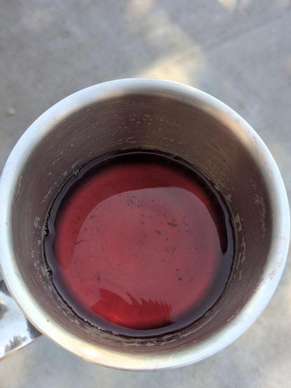 Photo of a stainless steel pot with about 2 cm of dark pink liquid in the bottom -- radish tea
